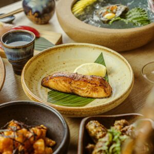 a wooden table topped with bowls filled with food